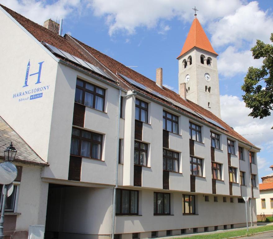 un bâtiment avec une tour d'horloge en arrière-plan dans l'établissement Harangtorony Szálló, à Kőszeg