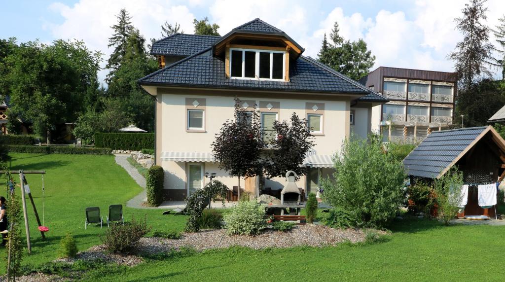 una casa con tetto blu e un cortile di Viktoria Apartments a Bled