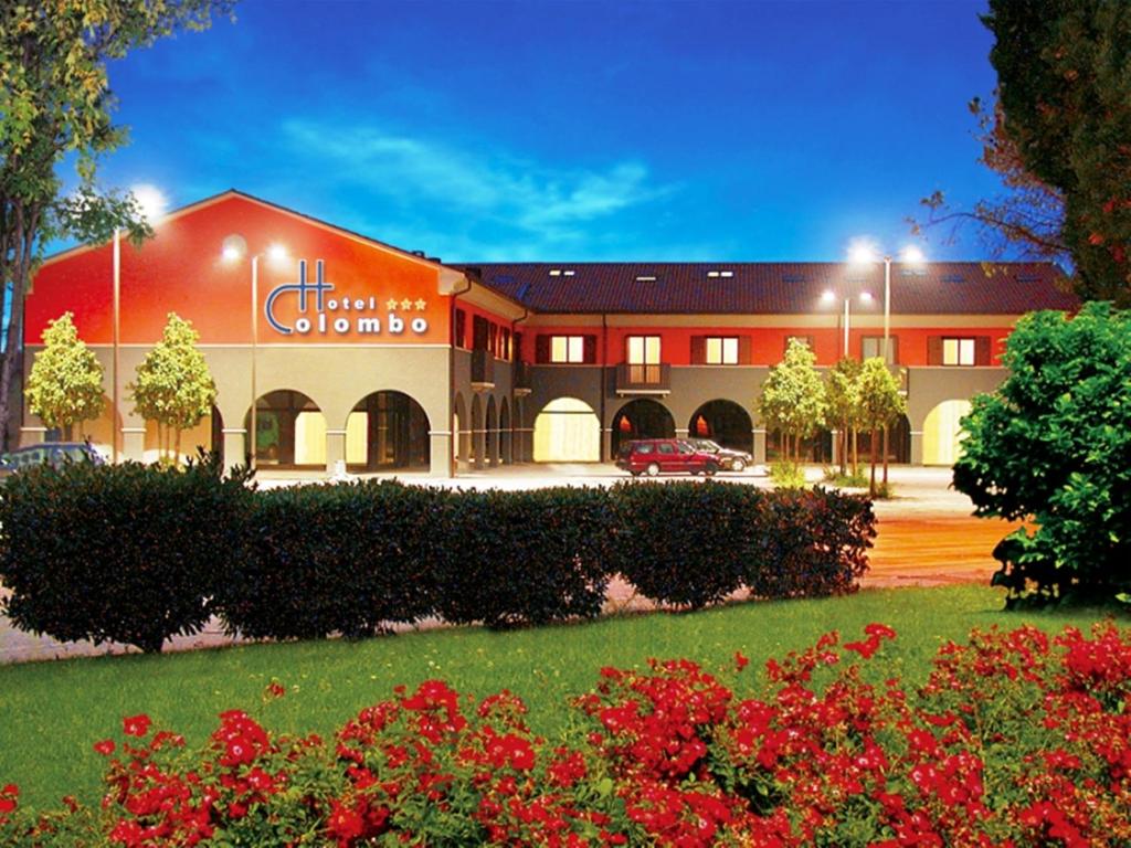 a large red building with a car parked in front of it at Hotel Colombo in Breda di Piave