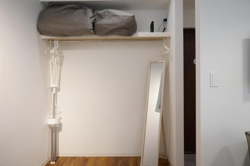 浜松市にあるCulinary Bed&Art2 403の棚とベッド、ランプが備わる客室です。
