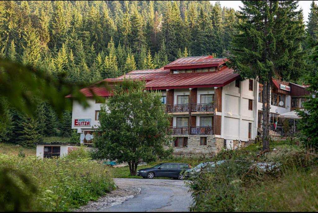 a building with a car parked in front of it at Hotel Elitza in Pamporovo