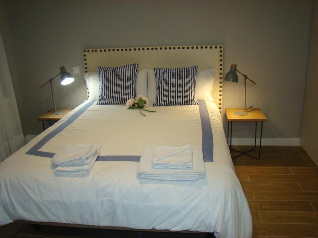 ein Schlafzimmer mit einem weißen Bett mit zwei Lampen und Handtüchern in der Unterkunft Apartamentos La Pereda Santander- Estudio E1 in Santander