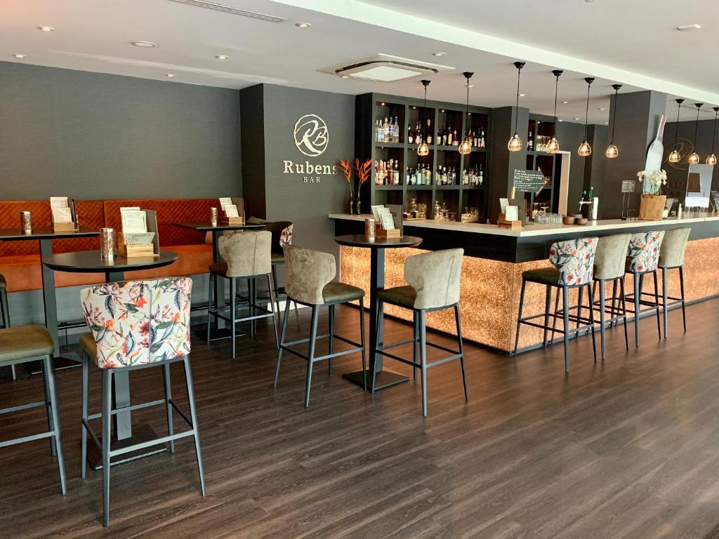 a bar in a restaurant with bar stools at Tulip Inn Leiden Centre in Leiden