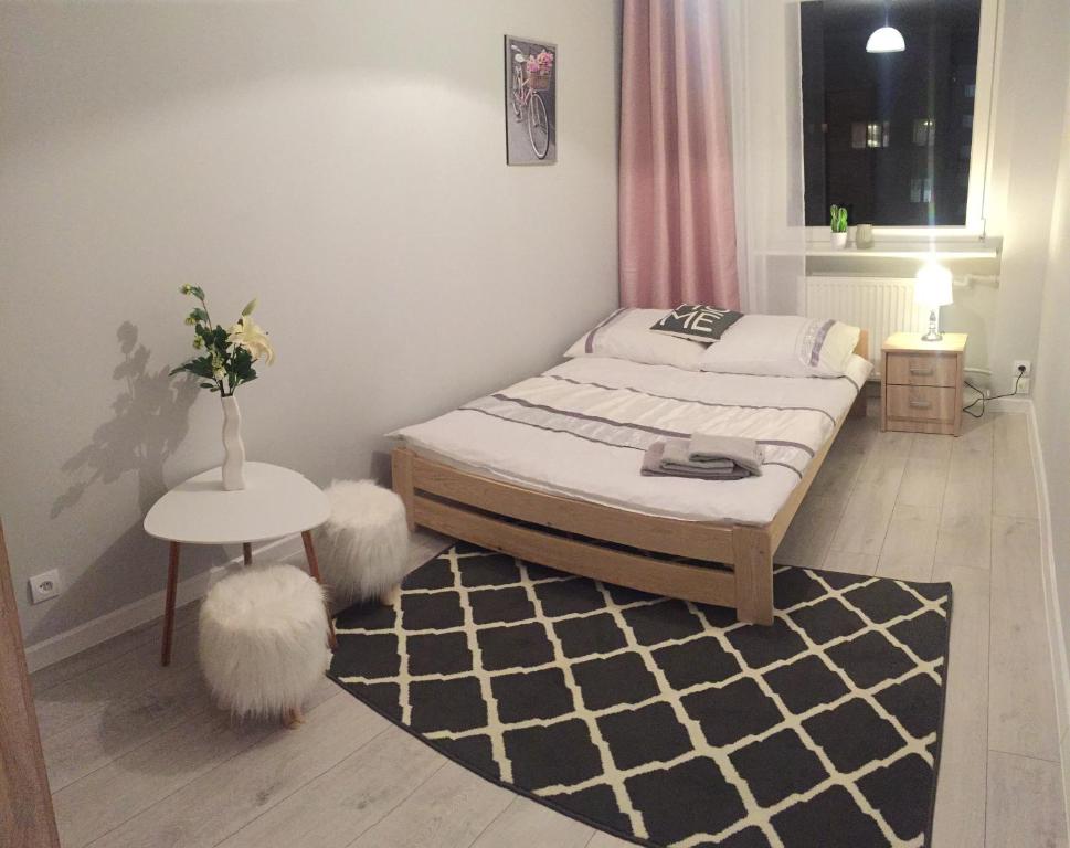 a small bedroom with a bed with two white fuzzy seats at BlaBlaFlat Świnoujście Grunwaldzka in Świnoujście