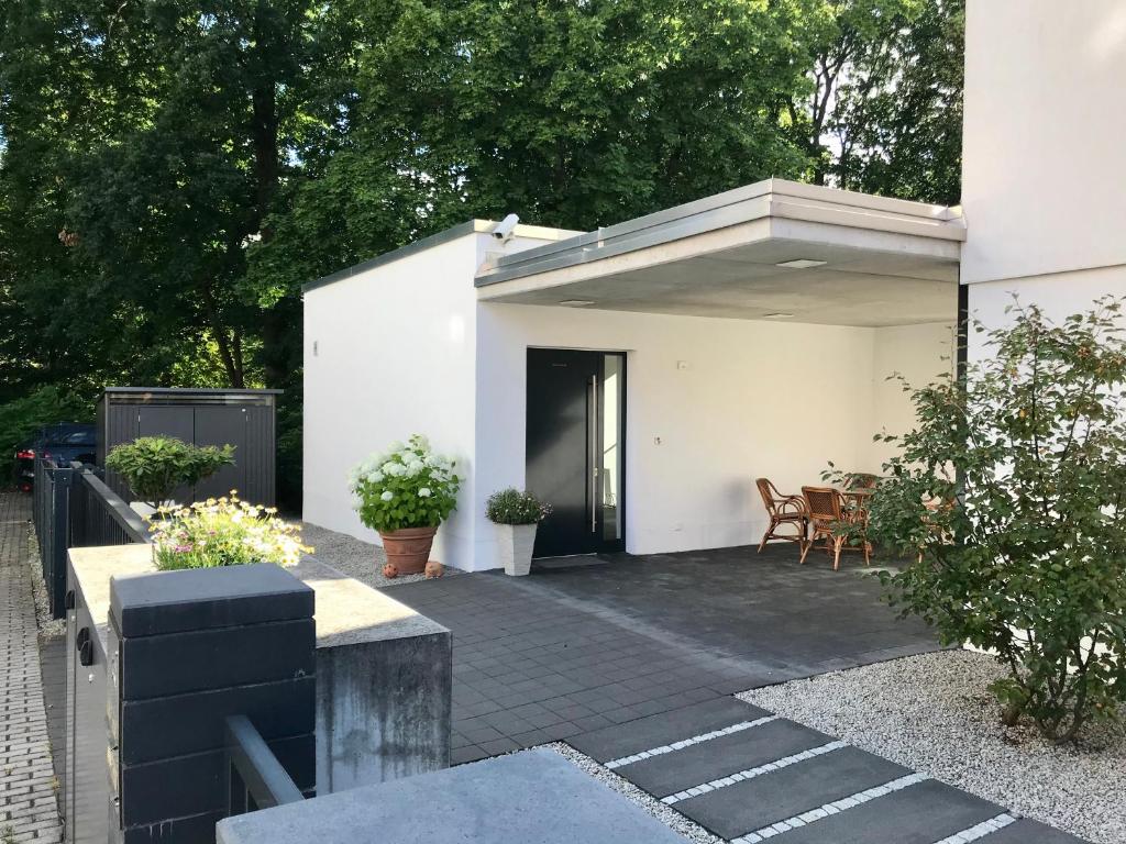 Dieses weiße Haus verfügt über eine Terrasse mit einem Tisch und Stühlen. in der Unterkunft Ferienhaus am Park am Röhrensee in Bayreuth