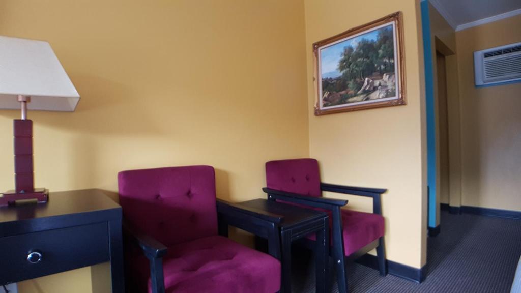 two chairs sitting next to a desk in a room at Alpine Inn & Suites in Revelstoke