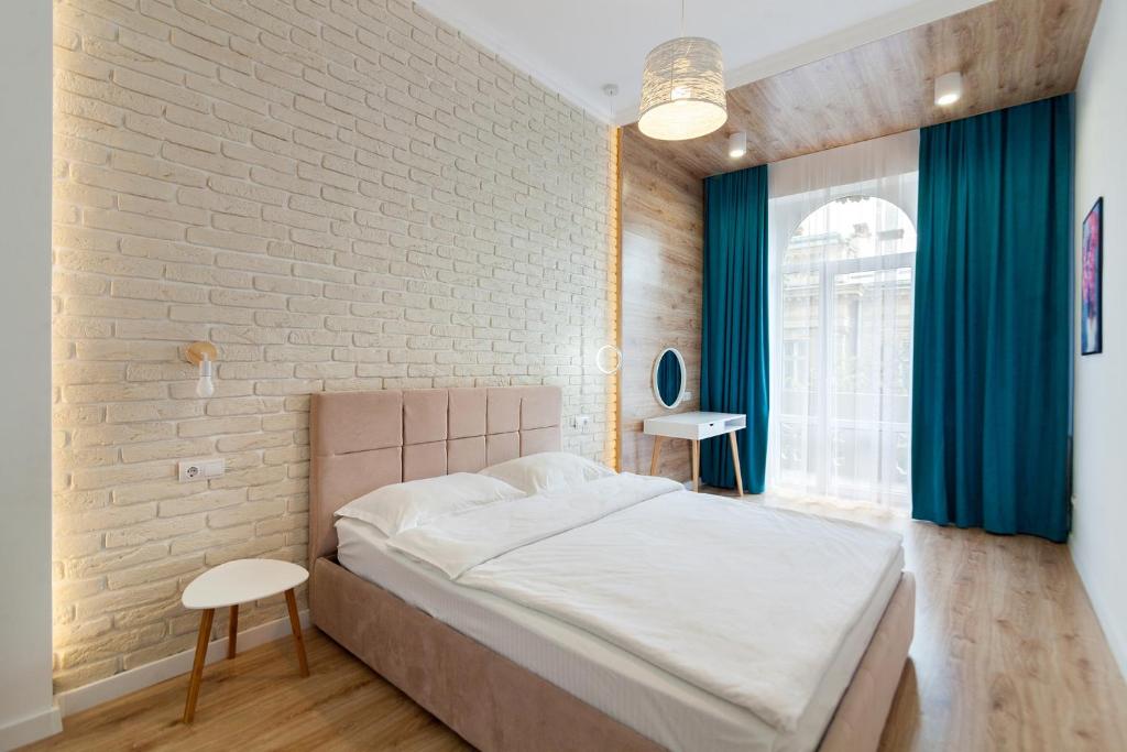 una camera con letto e muro di mattoni di LEOGRAND Three Bedrooms VIP Apartments on Kniazia Romana 12 a Lviv