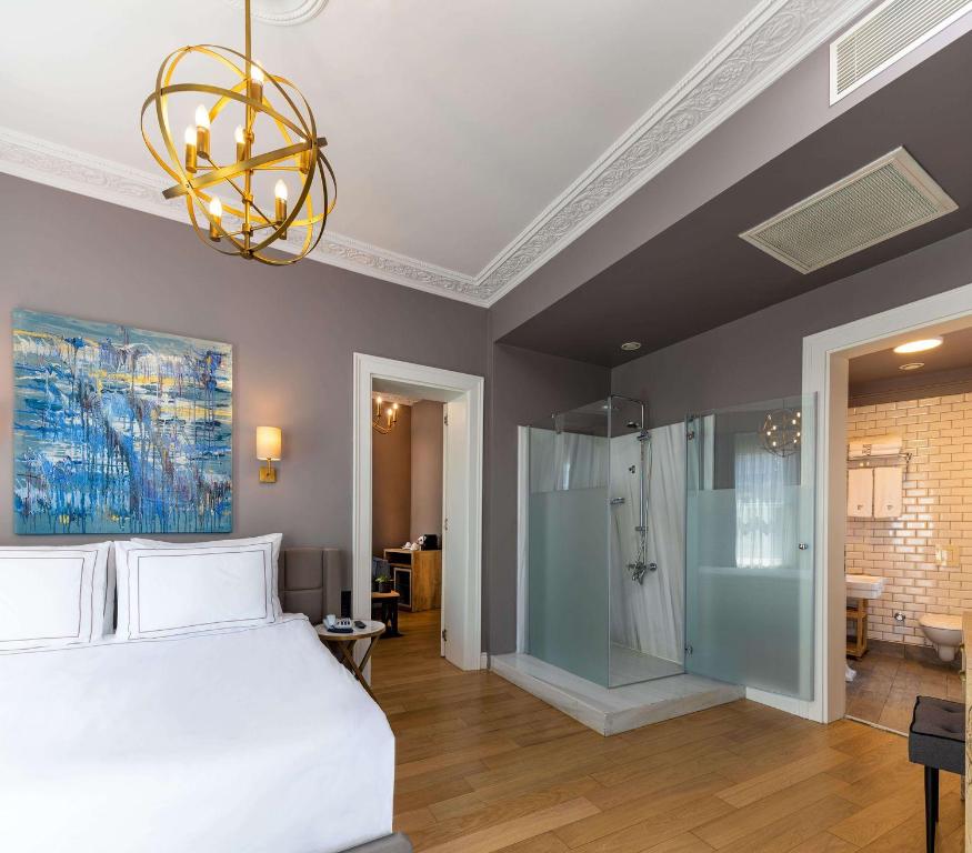 a bedroom with a bed and a shower and a chandelier at Petros Hotel in Istanbul
