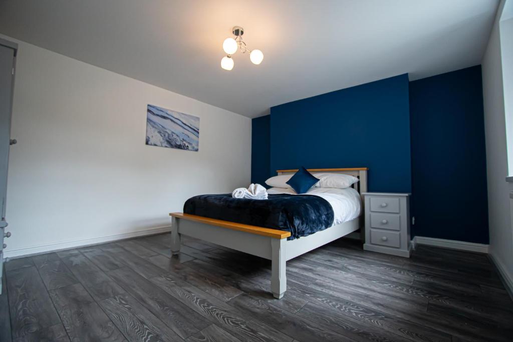 a bedroom with a bed with a blue accent wall at Clarence Retreat in Newport