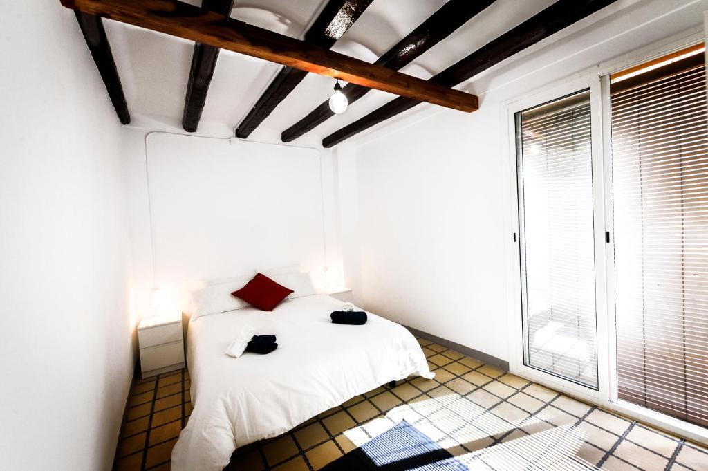 Design Club Reus في ريوس: غرفة نوم بسرير ابيض ونافذة كبيرة
