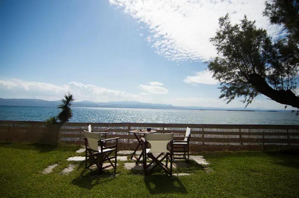 una mesa y sillas frente al agua en Seafront Villa Aggeliki en Erétria