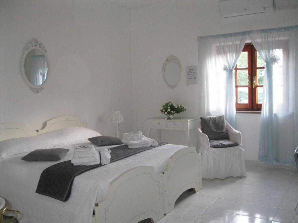 オルビアにあるB&B Il Gelsominoの白いベッドルーム(大きな白いベッド1台、椅子付)