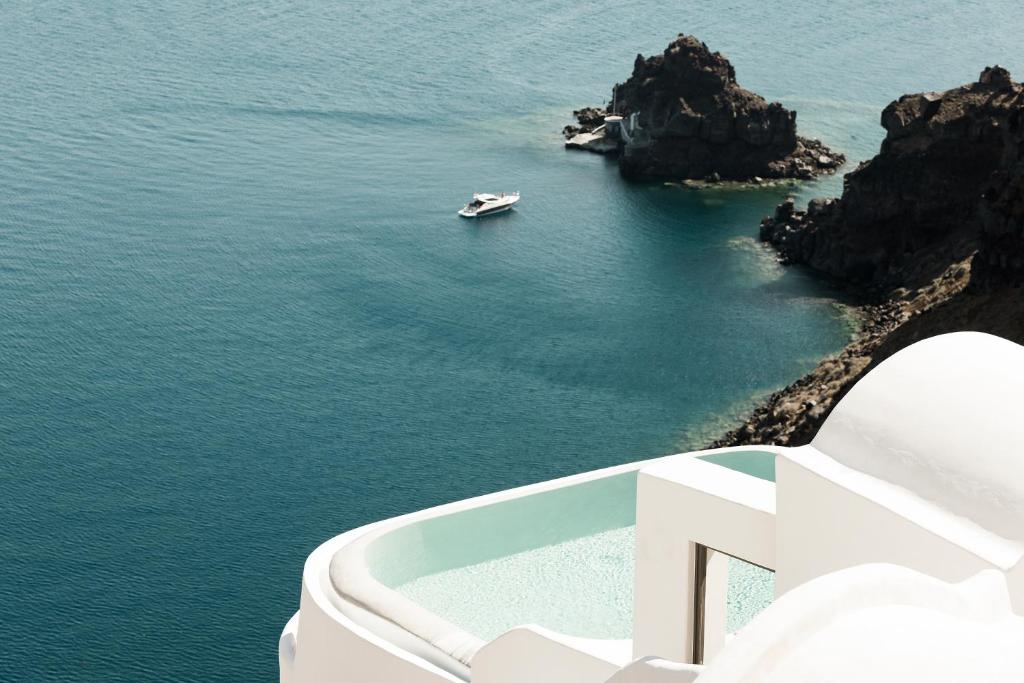 a boat in a body of water with a boat at Armenaki in Oia
