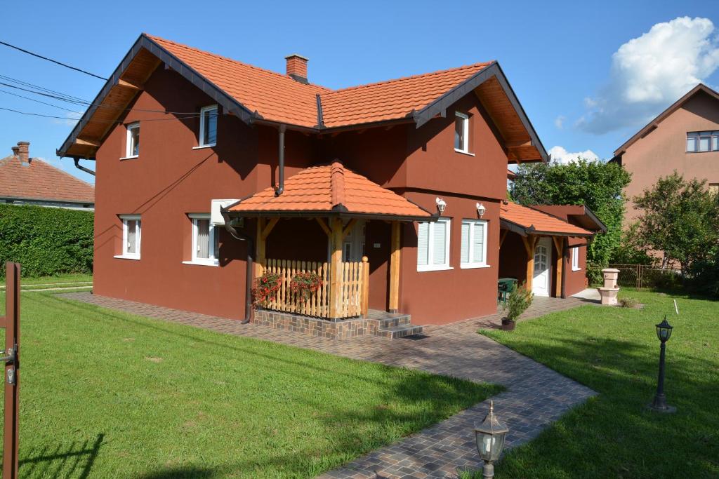 een huis met een rood dak en een tuin bij Aska Apartments Vrnjacka Banja in Vrnjačka Banja
