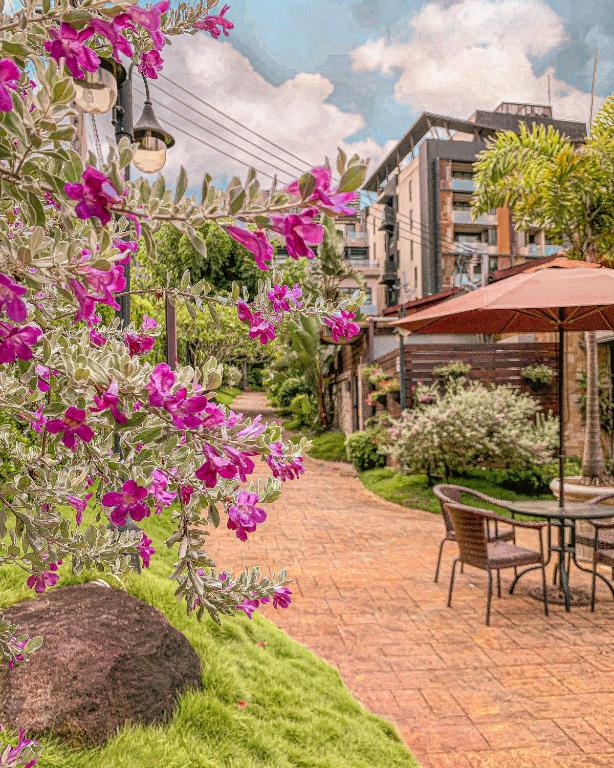 a patio with a table and chairs and purple flowers at Yage Hotspring House in Jiaoxi