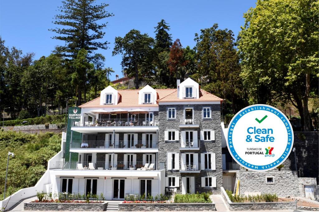 un bâtiment avec un panneau indiquant la propreté et la sécurité dans l'établissement OurMadeira - Babosas Village, gardénias and greenspaces, à Funchal