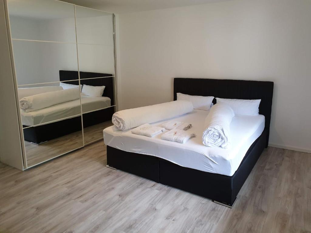 1 dormitorio con cama y espejo grande en Private and cozy Apartment in Refrath near Cologne, en Bergisch Gladbach