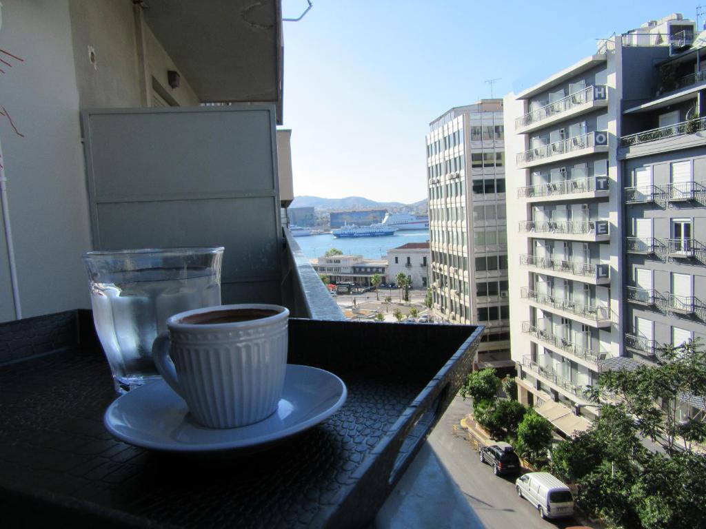 a cup of coffee on a table on a balcony at ΜΕ ΘΕΑ ΤΟ ΛΙΜΑΝΙ in Piraeus