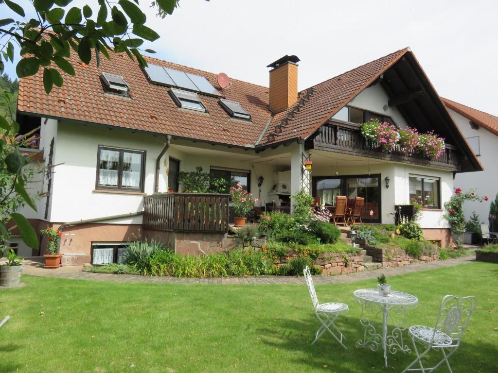 ein Haus mit zwei Stühlen und einem Tisch im Hof in der Unterkunft Ferienwohnungen Haus Albert in Großheubach