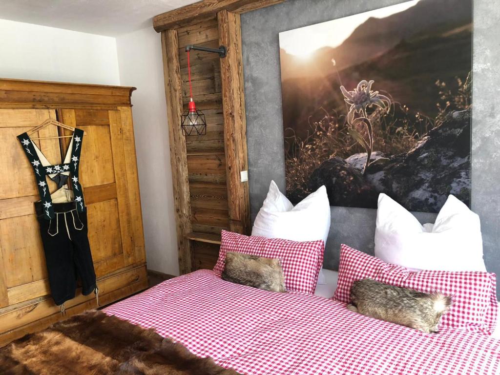 a bedroom with a bed with pillows and a painting at HOCH3 Ferienwohnung in Immenstadt im Allgäu