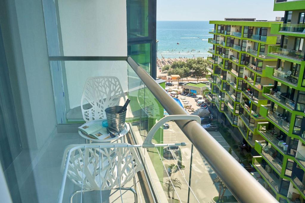 balkon z krzesłem i widokiem na ocean w obiekcie Studio Capri Spa n Pool Beach resort w mieście Năvodari