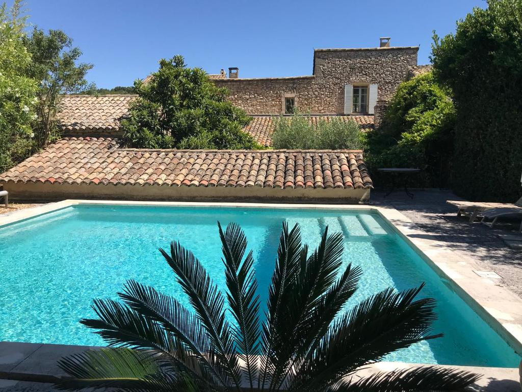 una piscina di fronte a una casa di Le mas jasmins a Ménerbes