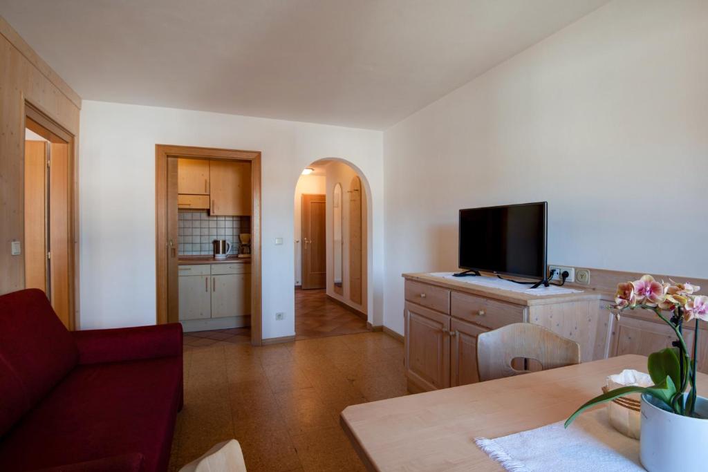 een woonkamer met een bank en een flatscreen-tv bij Apartment 7 - Zur Sonne in Laion