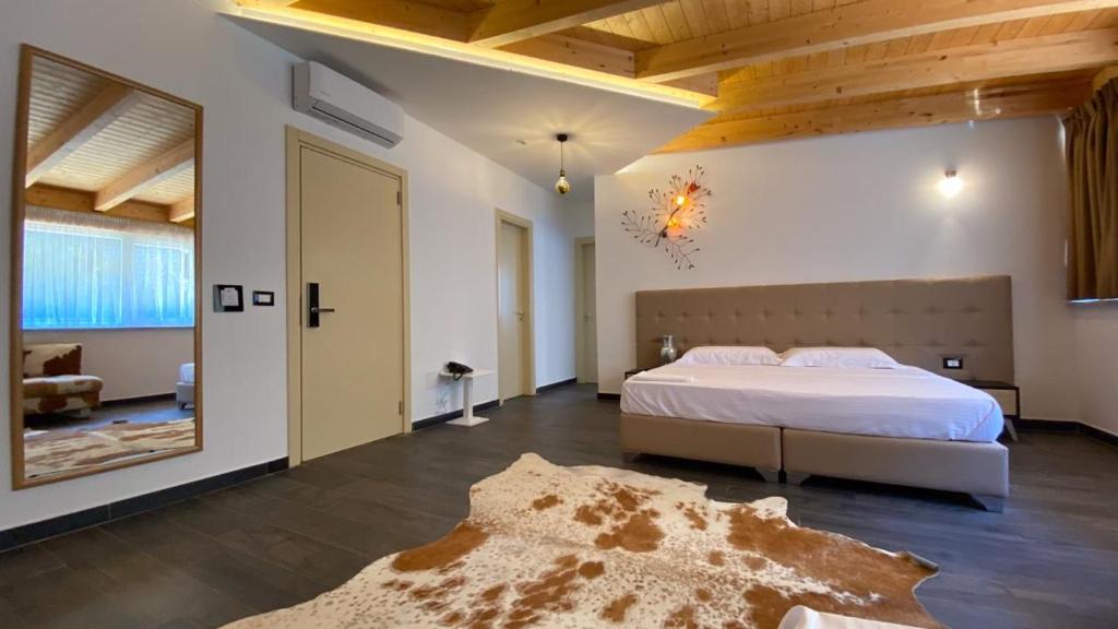 1 dormitorio grande con 1 cama y 1 alfombra en Mille Amici Hotel, en Shëngjin