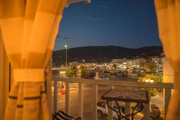 un balcón con vistas a un aparcamiento por la noche en Portogavrio Apartment, en Gavrion