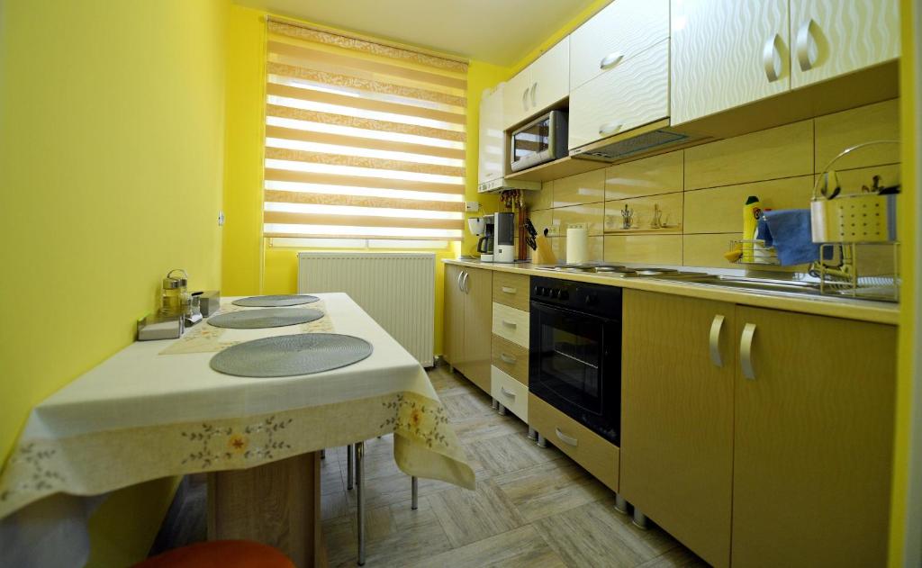 eine Küche mit gelben Wänden und einer weißen Arbeitsplatte in der Unterkunft Apartament TRIDENT in Haţeg