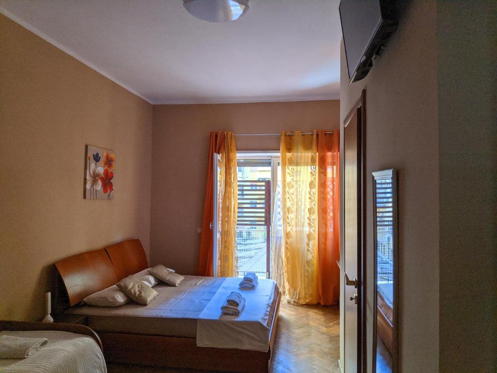 1 dormitorio con 1 cama y una ventana con cortinas de color naranja en B&B Gina Trastevere, en Roma