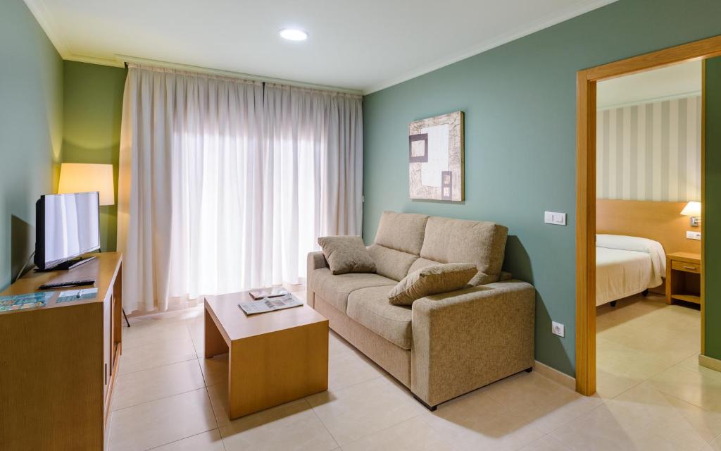 a living room with a couch and a bedroom at Apartamentos Trisquel in Sanxenxo