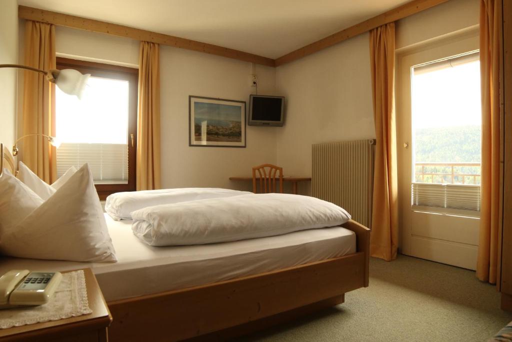 ノーヴァ・ポネンテにあるgasthof pension rösslのベッドルーム1室(ベッド1台、デスク、窓付)