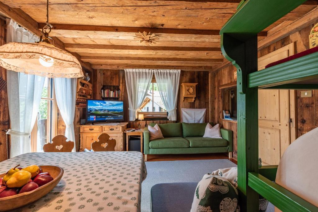 1 dormitorio con 1 cama y 1 sofá en una habitación en Kronplatz Ski Lodge, en Valdaora