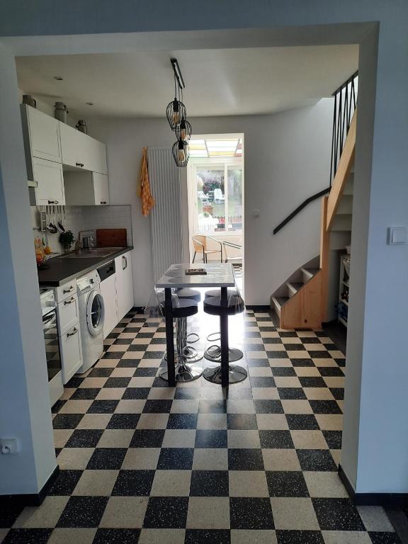 a kitchen with a table and a checkered floor at La Tanatte de wimereux sur la côte d opale in Wimereux