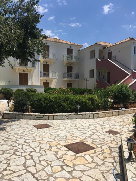 a stone patio in front of a building at Georges Estates Hotel in Stoupa