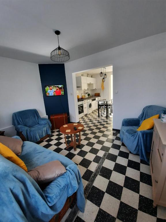 a living room with blue couches and a checkered floor at La Tanatte de wimereux sur la côte d opale in Wimereux