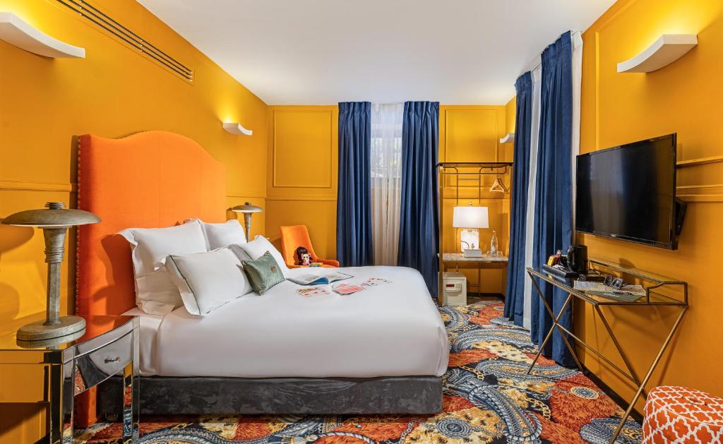 a hotel room with a bed and a flat screen tv at Villa Brown Moshava - a member of Brown Hotels in Jerusalem