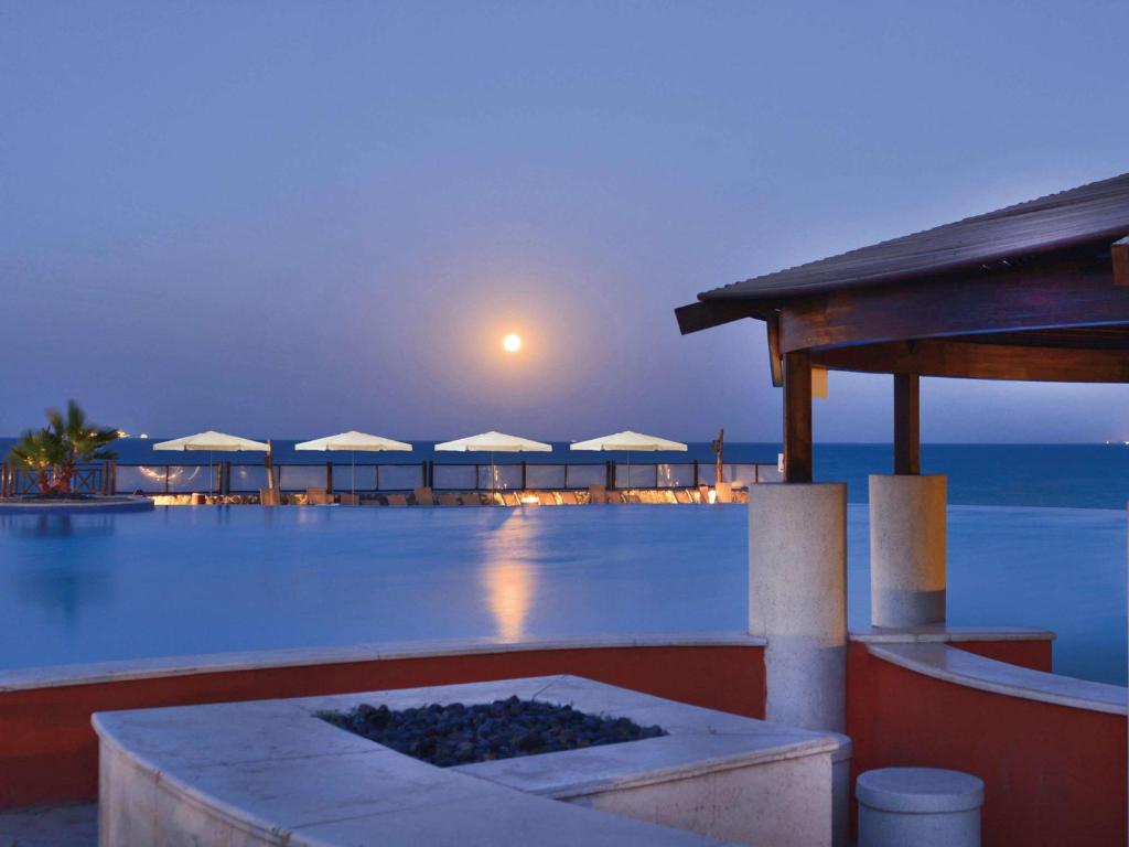 アインソフナにあるモーベンピック リゾート エル ソフナのリゾートの景色を望む客室で、夜はプールを利用できます。