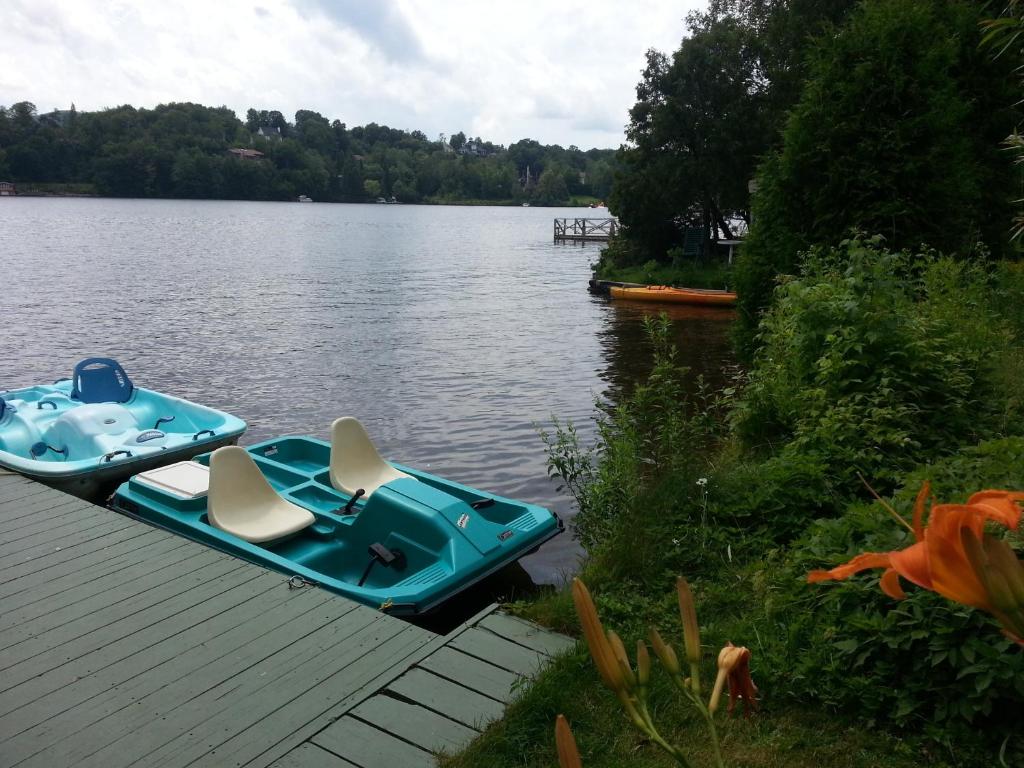 two boats sitting on a dock on a lake at Auberge Aux Nuits de Rêve in Sainte-Agathe-des-Monts