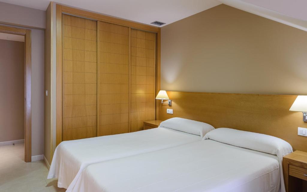 A bed or beds in a room at Apartamentos Trisquel