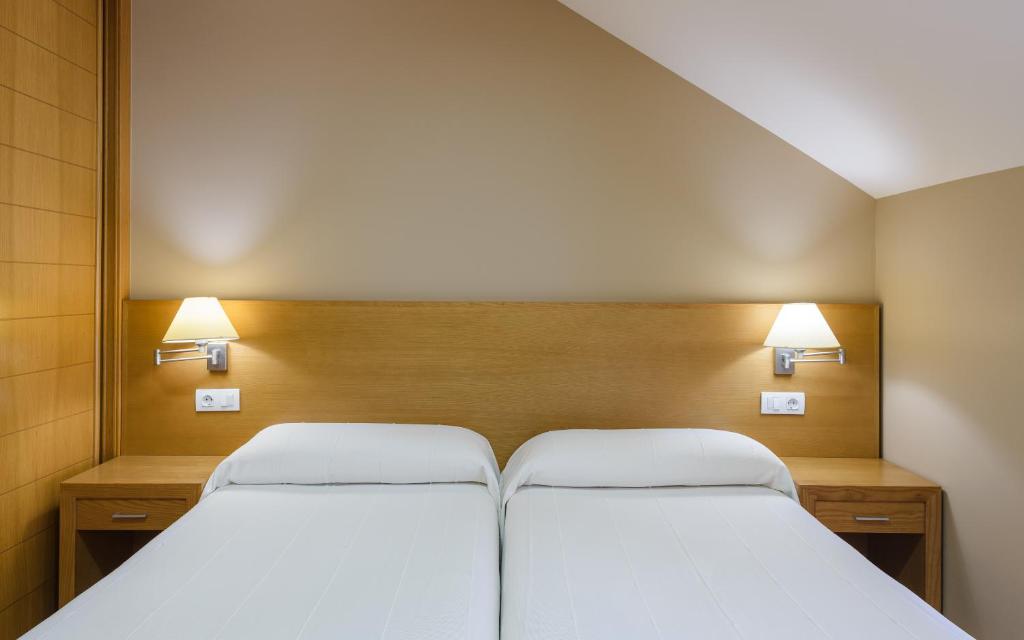 A bed or beds in a room at Apartamentos Trisquel