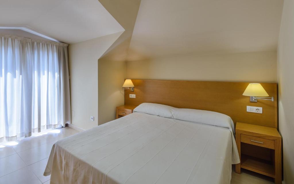 A bed or beds in a room at Apartamentos Trisquel