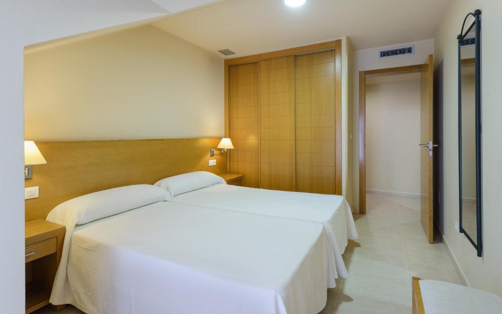 A bed or beds in a room at Apartamentos Trisquel