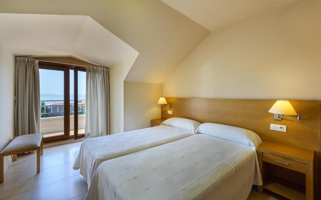 A bed or beds in a room at Apartamentos Trisquel