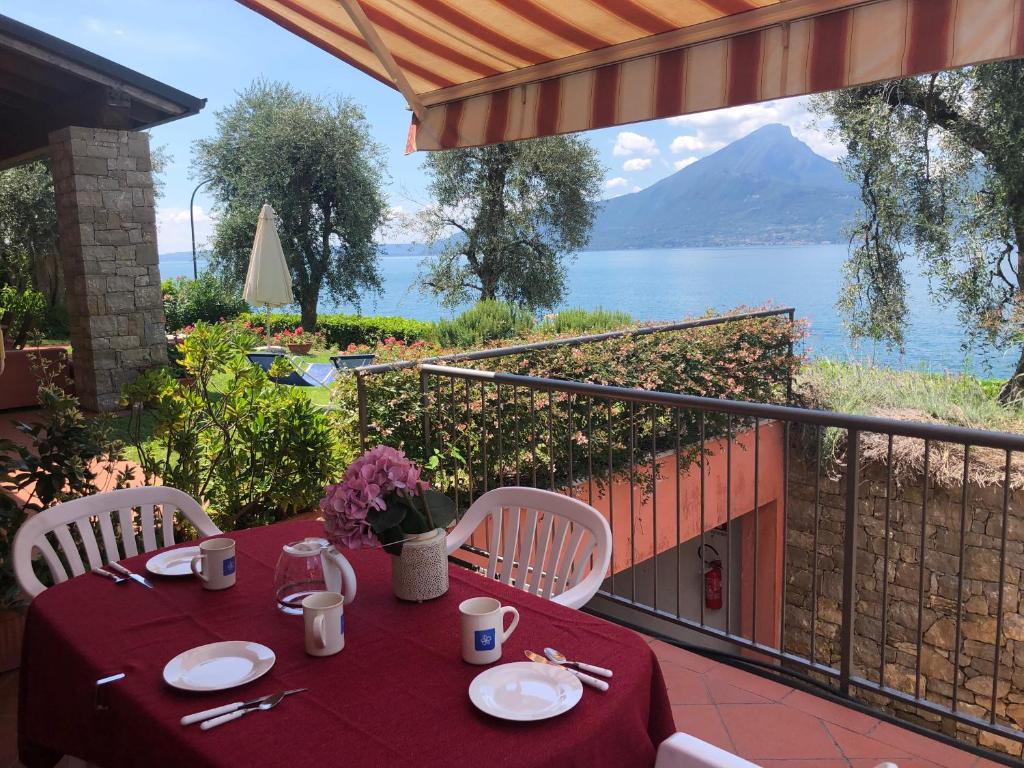 a table and chairs with a view of the water at Residence Villa al Lido in Brenzone sul Garda