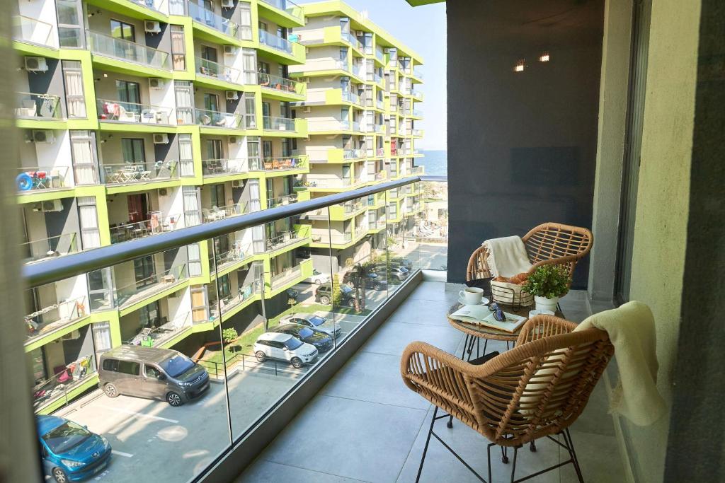 d'un balcon avec des chaises et une vue sur un bâtiment. dans l'établissement Vanilla Luxury Apartment Spa n Pool beach resort, à Mamaia Nord – Năvodari