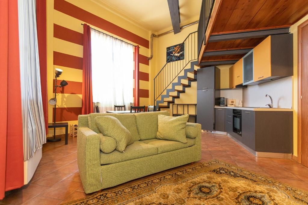 un soggiorno con divano e una scala di Antico Opificio Sasso Alloro a Bra