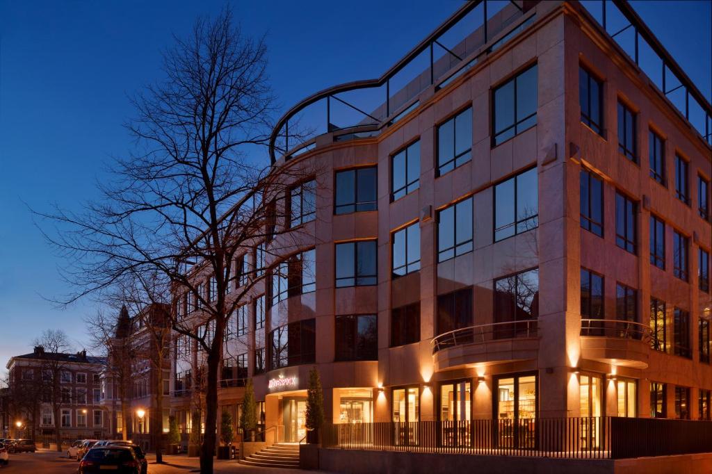 a large brick building on a city street at night at Mövenpick Hotel The Hague in The Hague