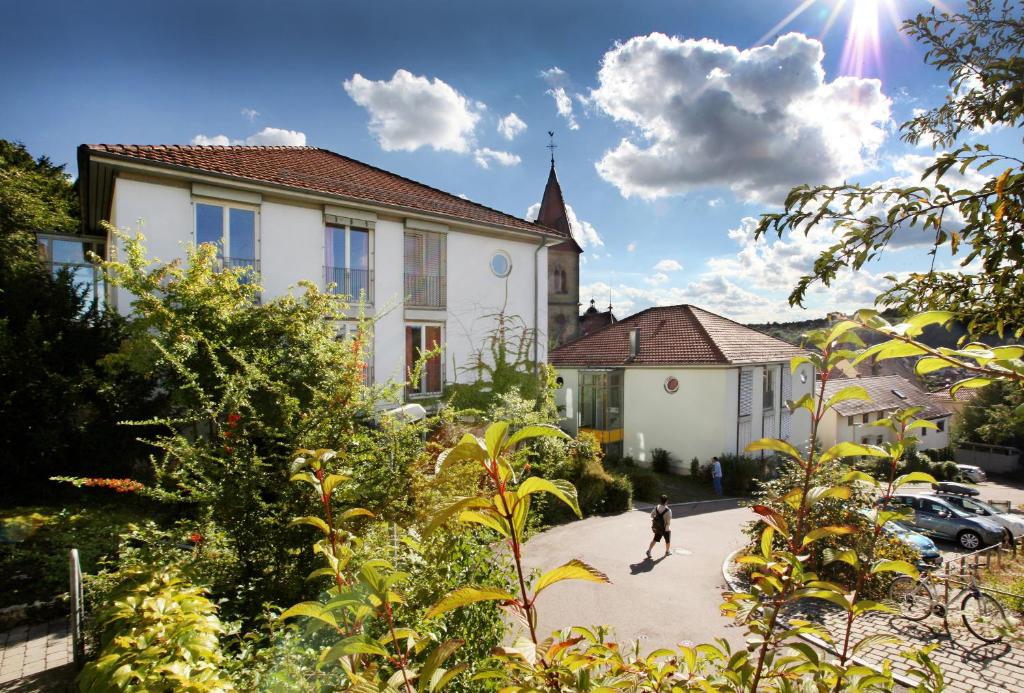 un homme marchant dans une allée en face d'une maison dans l'établissement Gästehaus Goethe-Institut Schwäbisch Hall, à Schwäbisch Hall